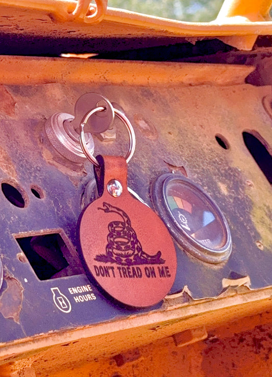 Keychain with 'Don't Tread on Me' design attached to a vehicle